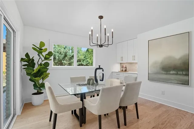 a dining room with furniture potted plants and wooden floor