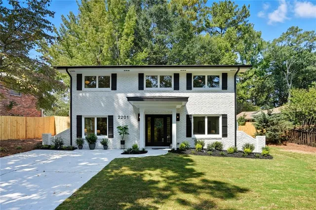 a front view of a house with a yard and trees