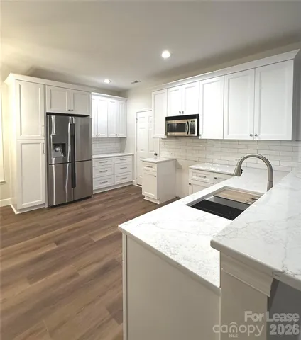a kitchen with granite countertop a refrigerator and a sink