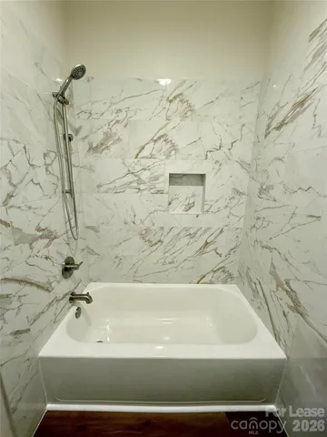 an empty room with wooden floor fireplace and windows