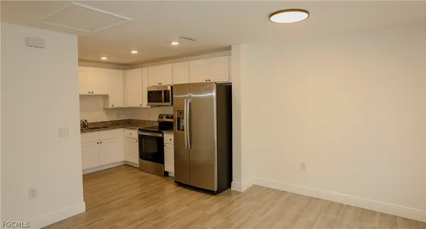 a kitchen with a refrigerator freezer and a stove top oven