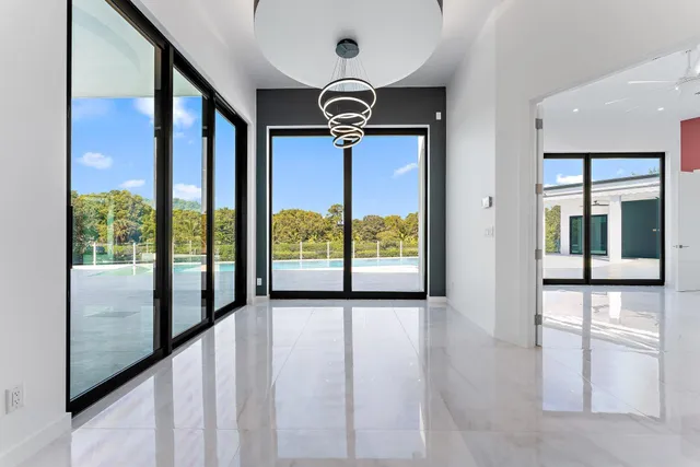 an aerial view of a residential houses with outdoor space and a lake view