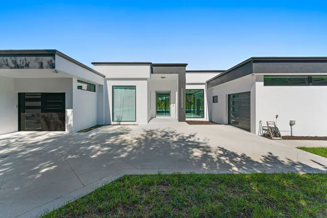 a large white kitchen with a large window and stainless steel appliances