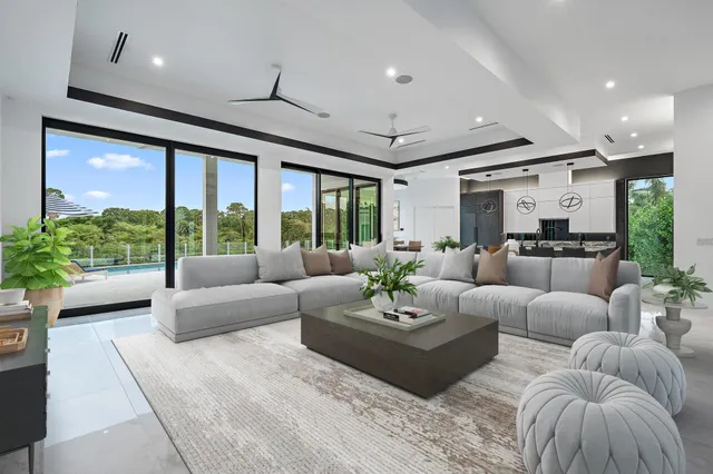an empty room with chandelier fan and windows