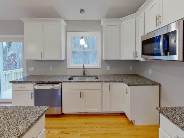 a kitchen with granite countertop a sink and a stove