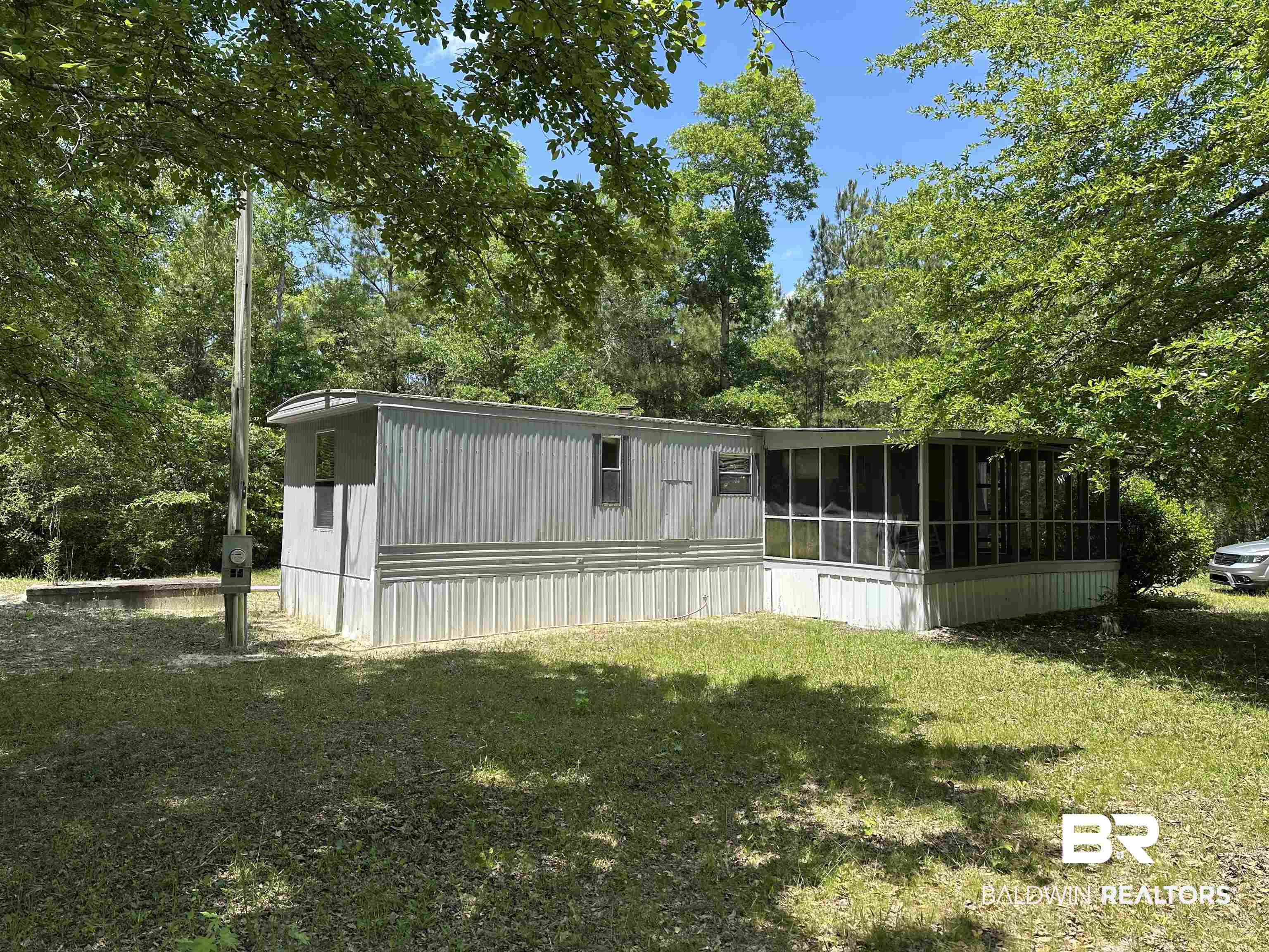 15660 Kennedy Road Bon Secour, AL 36511 - Photo 4 of 9 Rear view of house featuring a sunroom and a yard