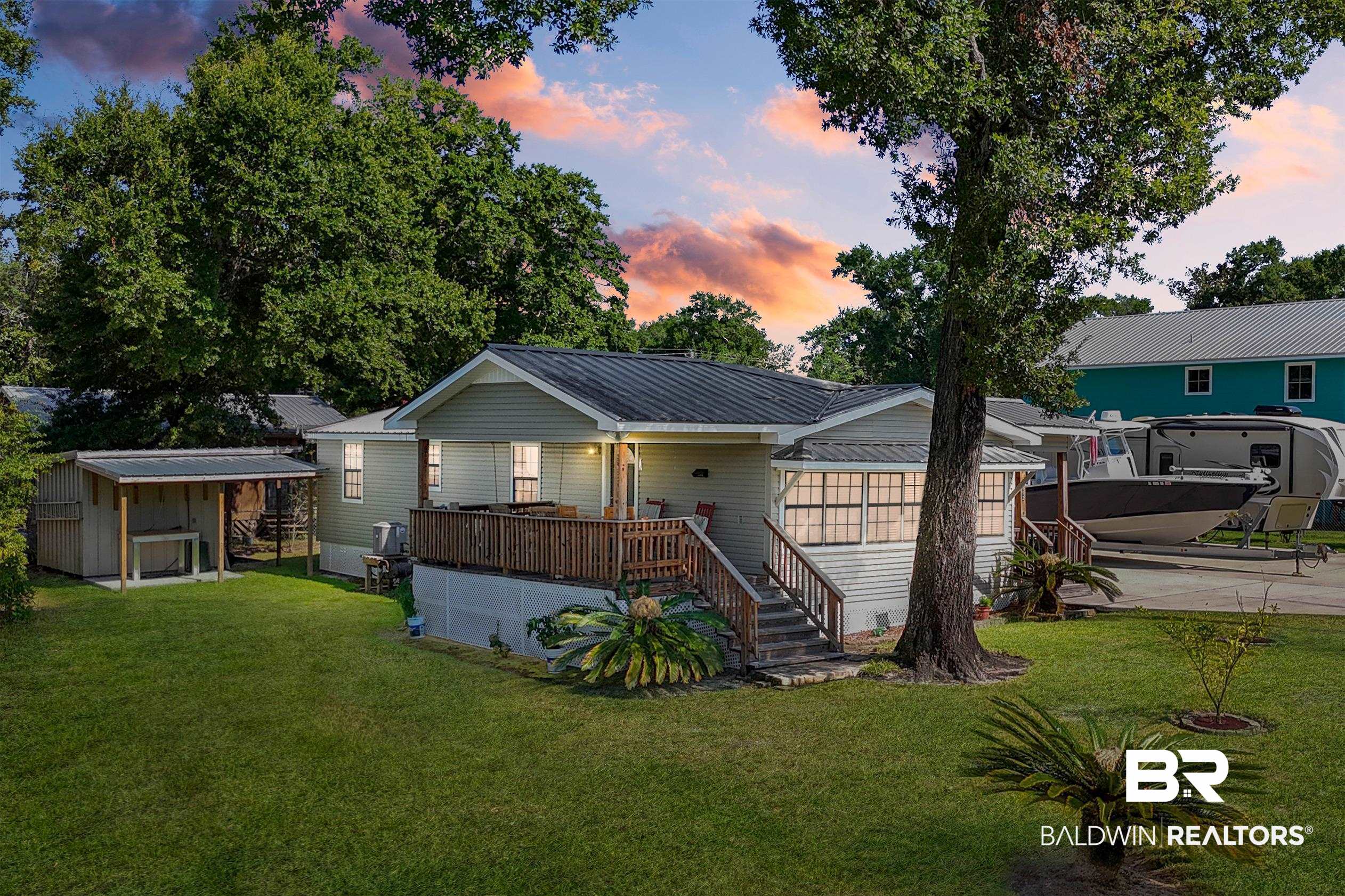 5392 Ornacor Avenue Orange Beach, AL 36561 - Photo 1 of 48 View of front of property featuring a wooden deck and a lawn