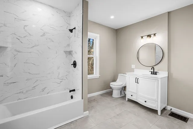 a bathroom with a toilet a sink a mirror and a bathtub