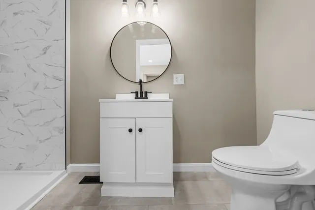 a bathroom with a toilet a sink and mirror