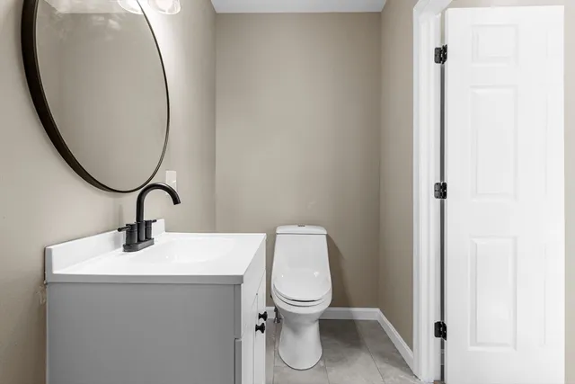 a bathroom with a toilet a sink and mirror