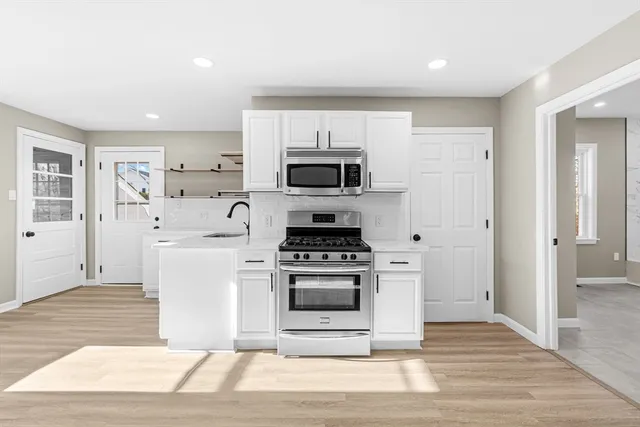 a kitchen with a stove and a white cabinets