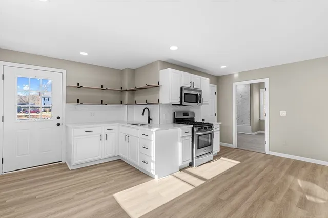 a kitchen with white cabinets stainless steel appliances and sink