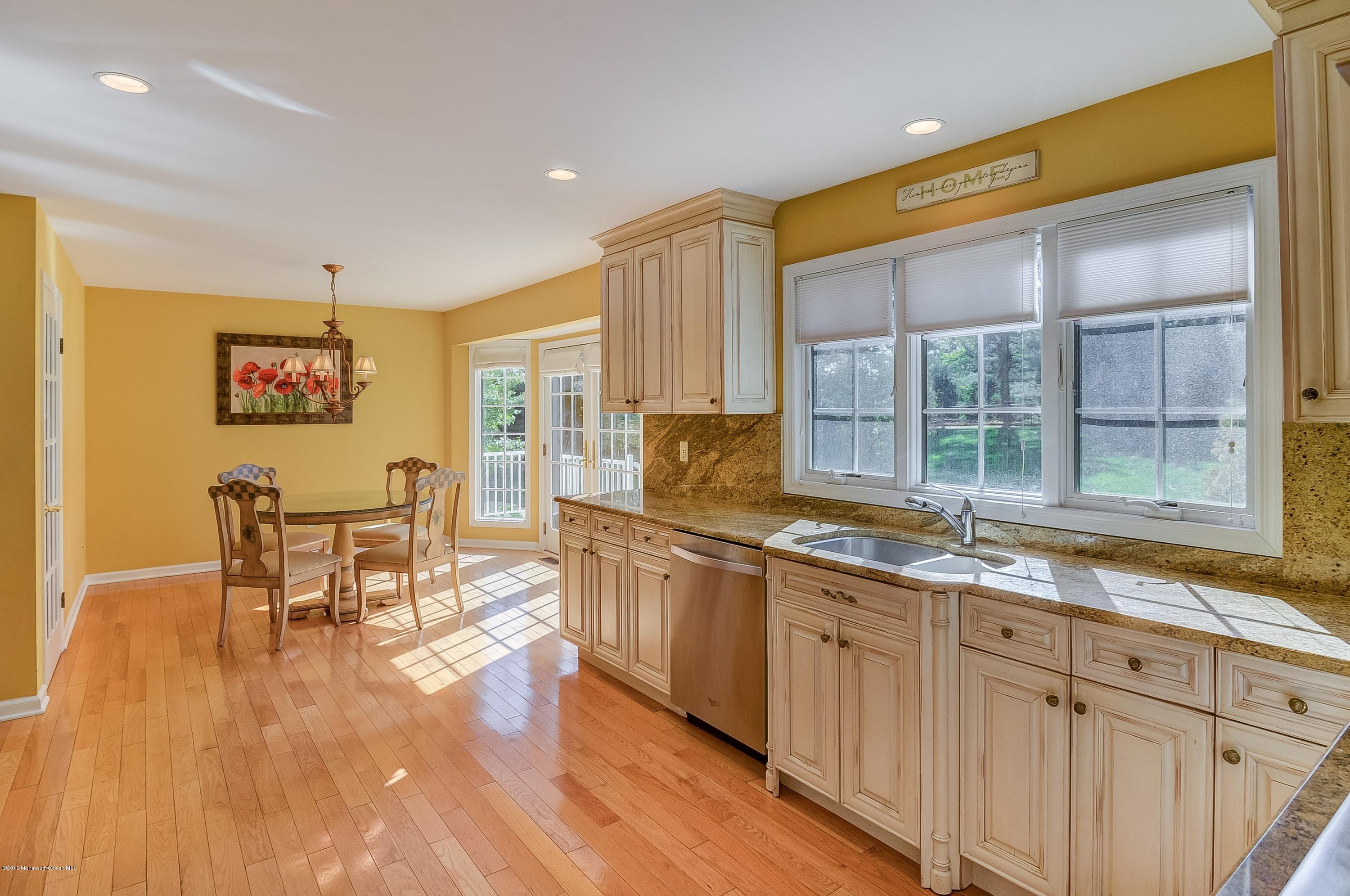 490 Burlington Road Freehold, NJ 07728 - Photo 12 of 34 a kitchen with wooden floors and wooden cabinets