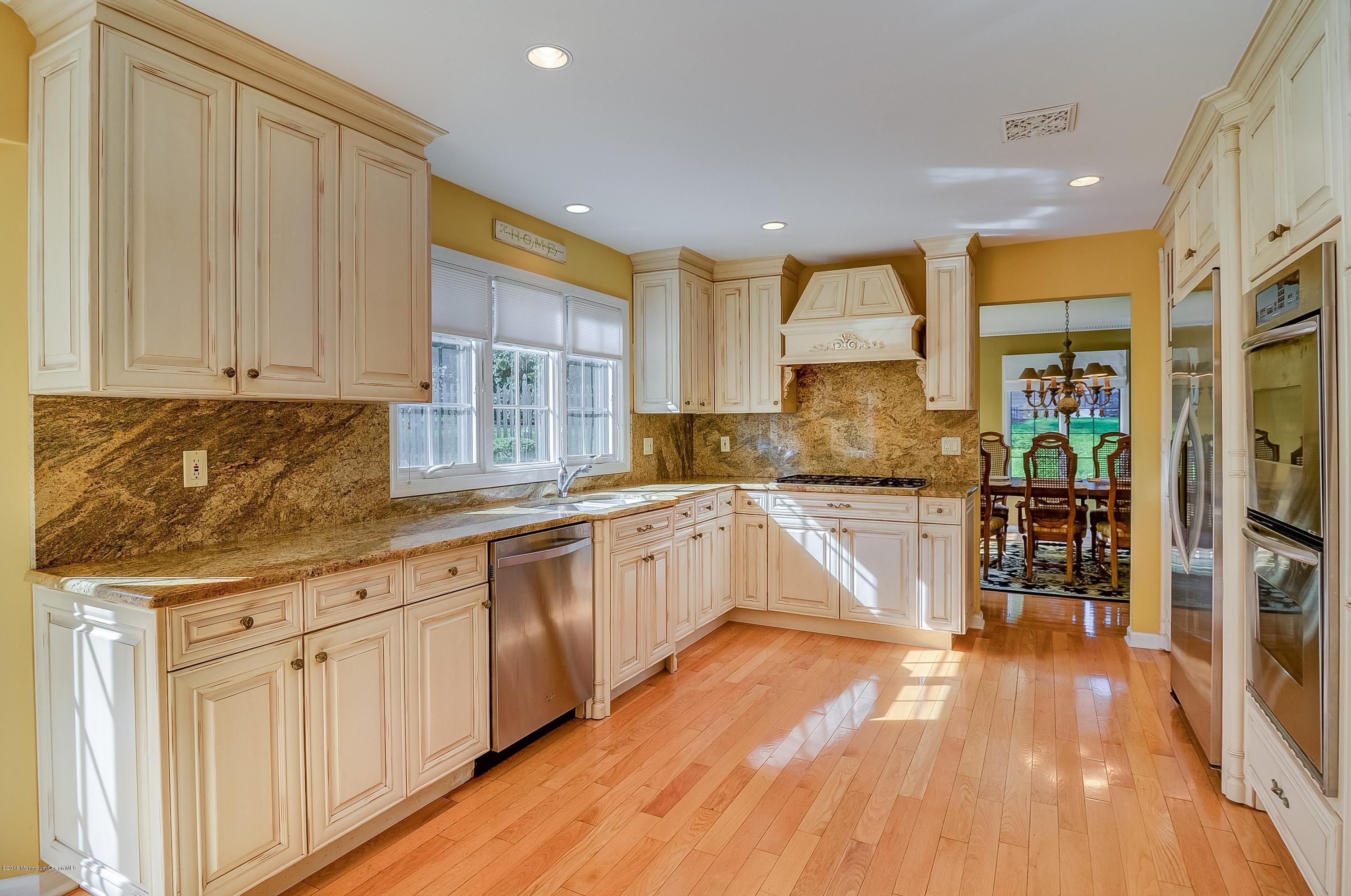 490 Burlington Road Freehold, NJ 07728 - Photo 13 of 34 a kitchen with granite countertop white cabinets and wooden floor