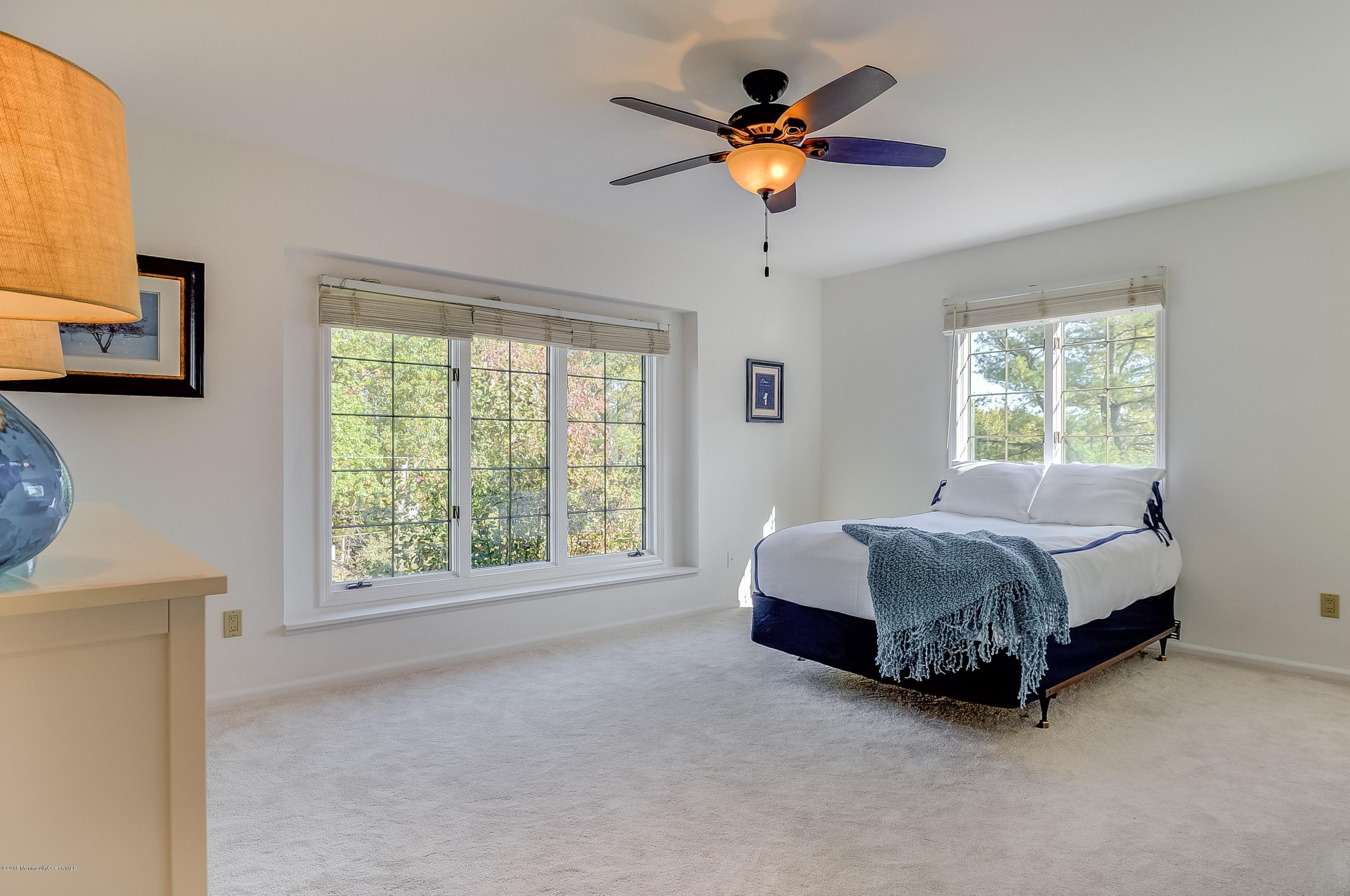 490 Burlington Road Freehold, NJ 07728 - Photo 27 of 34 a spacious bedroom with a bed and a chandelier