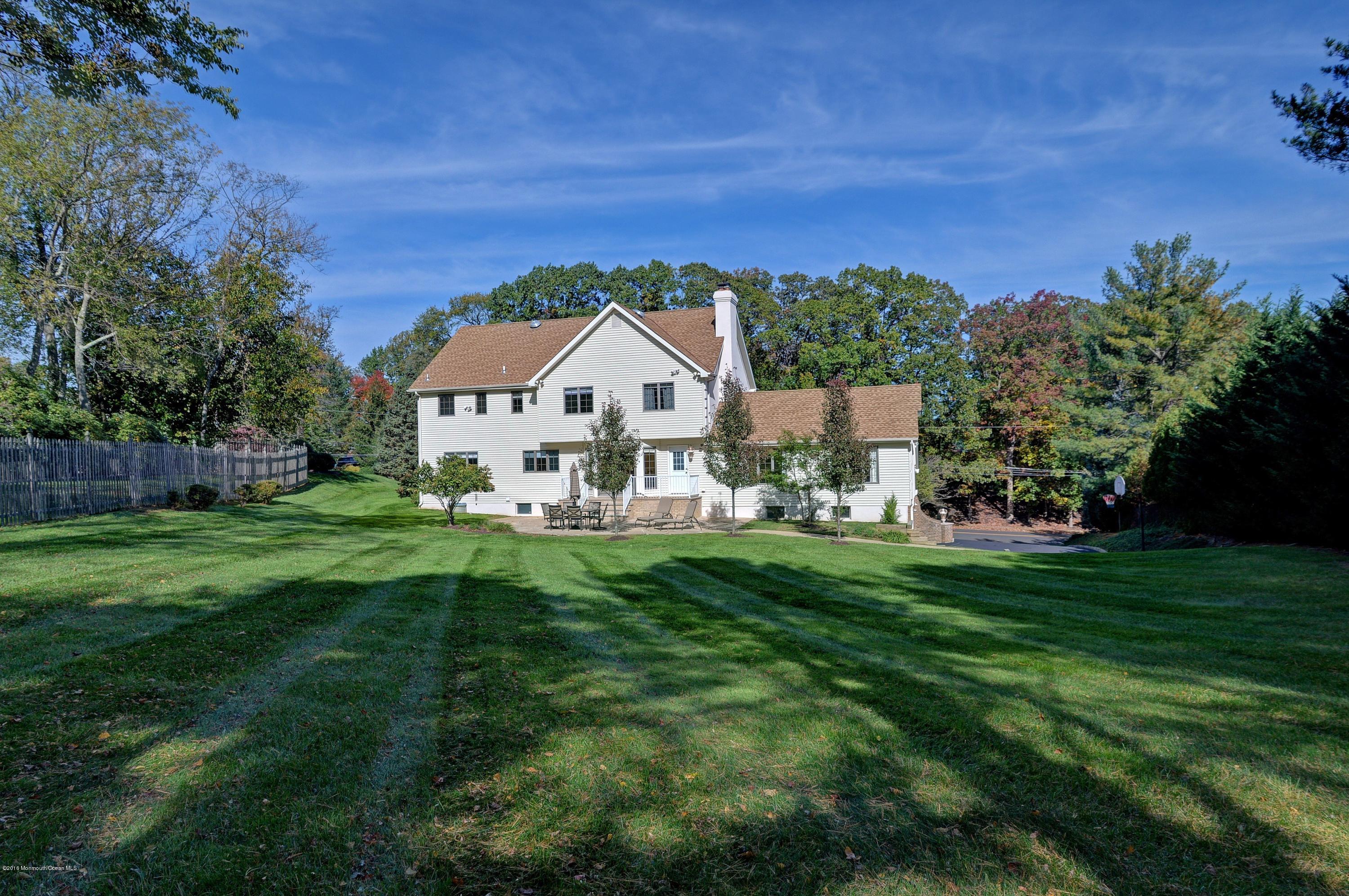 490 Burlington Road Freehold, NJ 07728 - Photo 33 of 34 a view of a big house with a big yard and large trees