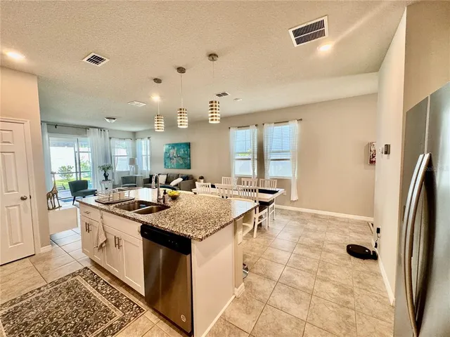 a kitchen with a stove a sink a microwave a refrigerator and cabinets