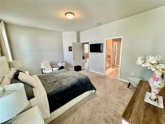 a bedroom with a bed a couch and a window