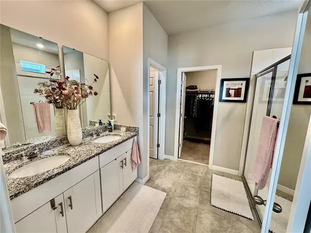 a bathroom with double vanity and a mirror