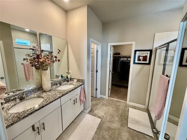 a view of a hallway with wooden floor and a bathroom