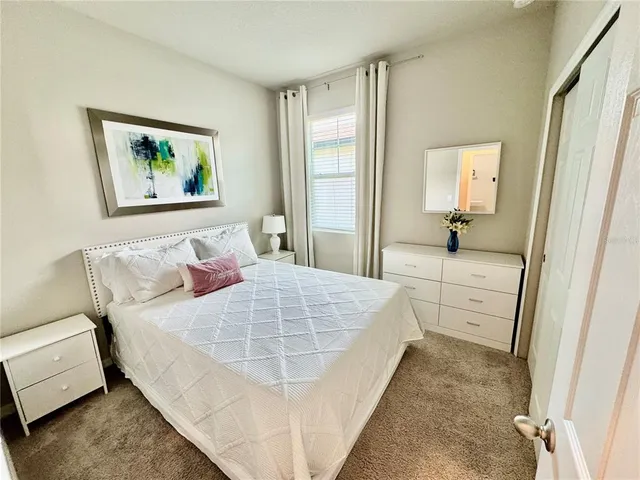 a bedroom with a bed and a painting on the wall