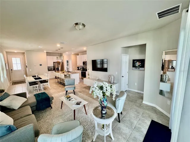a living room with furniture a window and a flat screen tv