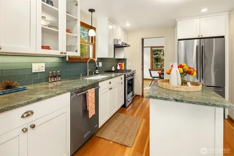 a kitchen with stainless steel appliances granite countertop a sink and a refrigerator