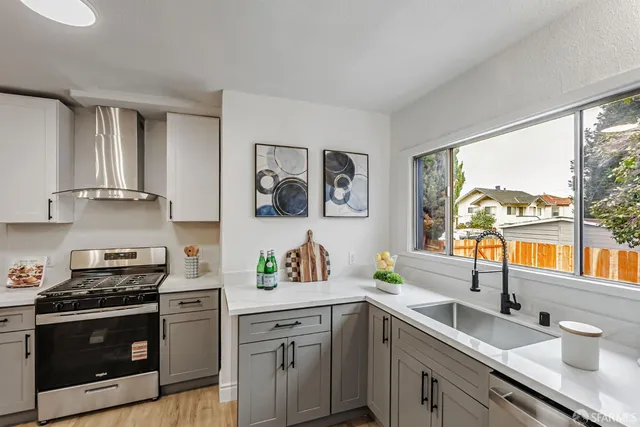 a kitchen with stainless steel appliances a sink a stove and a window