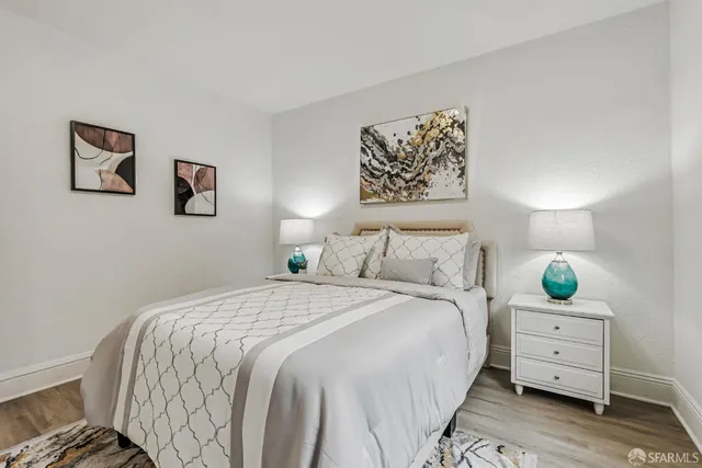 a bedroom with a bed and a lamp on dresser