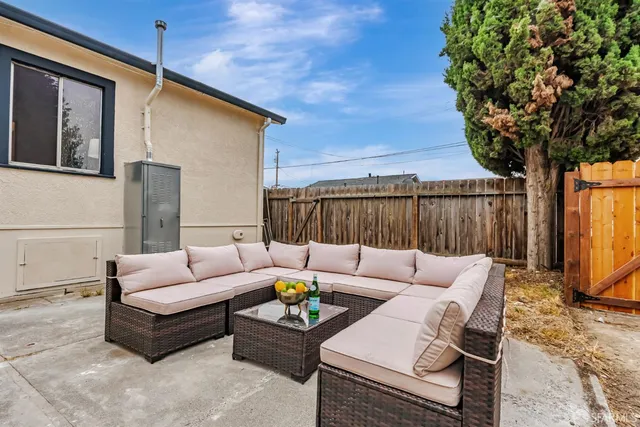 a backyard of a house with a yard and outdoor seating