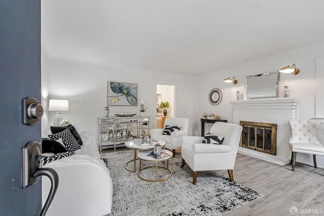 a living room with furniture a fireplace and wooden floor