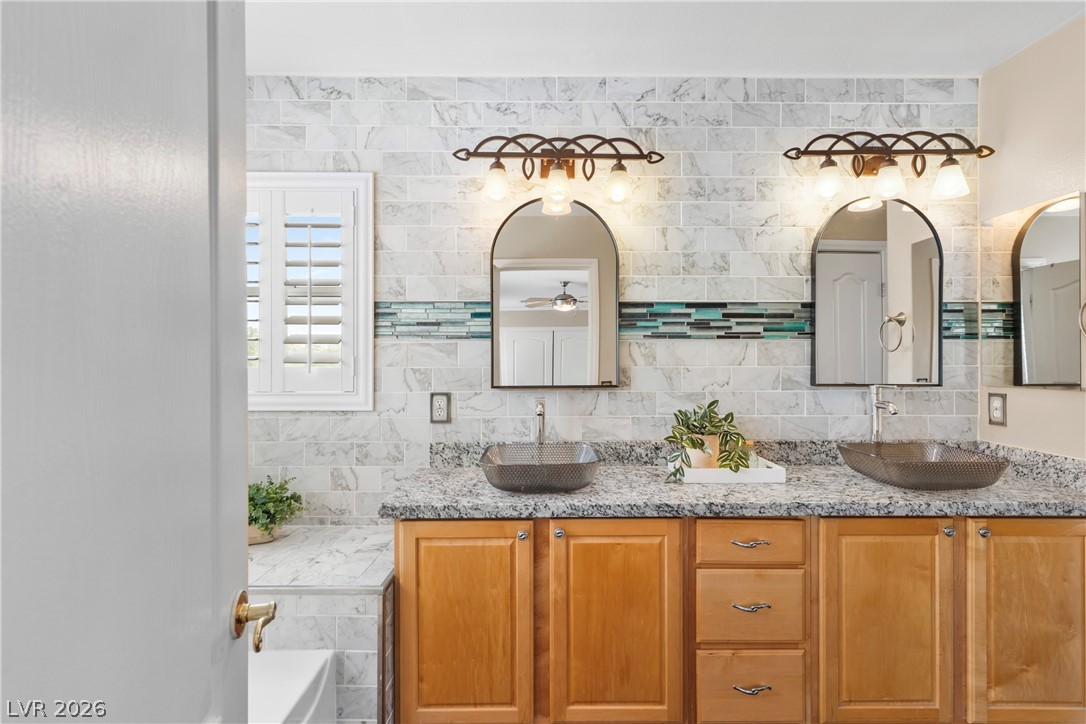 708 Vortex Avenue Henderson, NV 89002 - Photo 31 of 71 Double vessel sinks and wood cabinetry create a refreshing and elegant bathroom oasis.