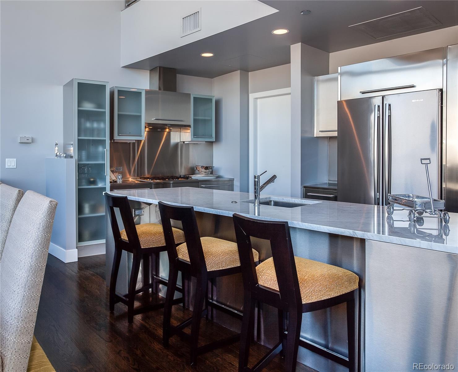1200 Acoma Street, Unit 603 Denver, CO 80204 - Photo 13 of 30 a kitchen with stainless steel appliances kitchen island granite countertop a kitchen island and chairs in it