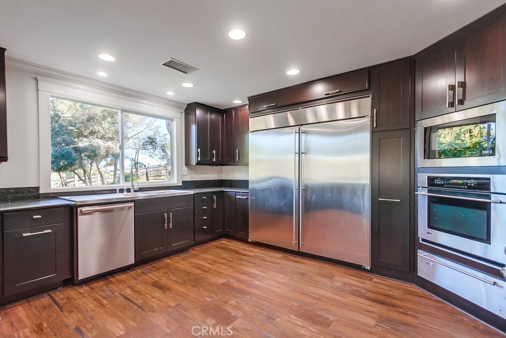 3927 Valle Del Sol Bonsall, CA 92003 - Photo 9 of 41 a large kitchen with stainless steel appliances granite countertop a refrigerator a sink dishwasher a stove and a large window