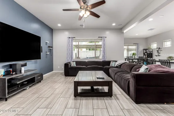 a living room with couches and kitchen view with wooden floor