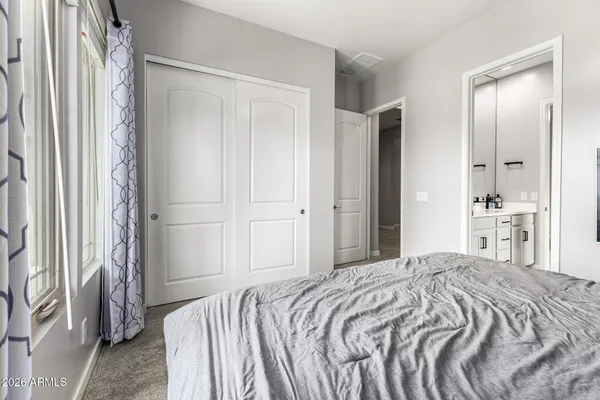 a spacious bedroom with a bed and a chandelier