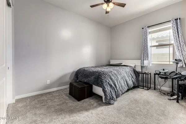 a bed sitting in a spacious bedroom next to a window