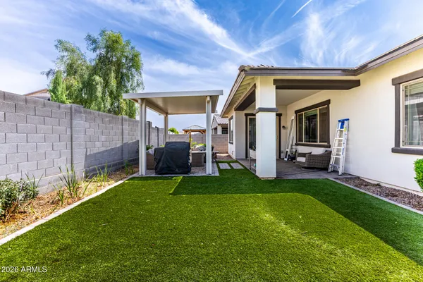 a view of a house with backyard and sitting area
