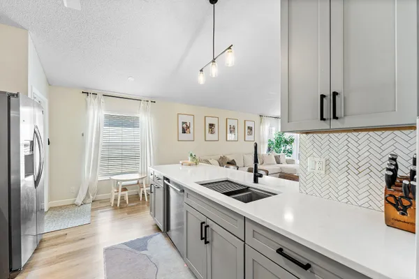a kitchen that has a lot of cabinets in it and wooden floor