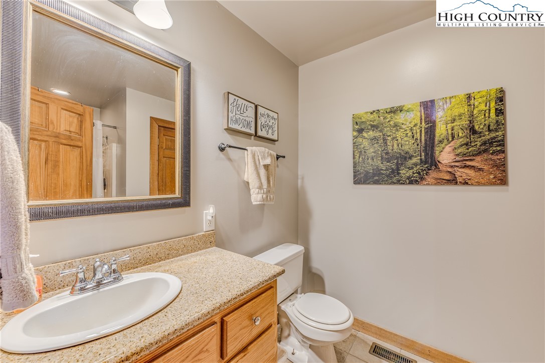 888 Benjamin Drive Boone, NC 28607 - Photo 20 of 38 a bathroom with a granite countertop sink mirror vanity and toilet
