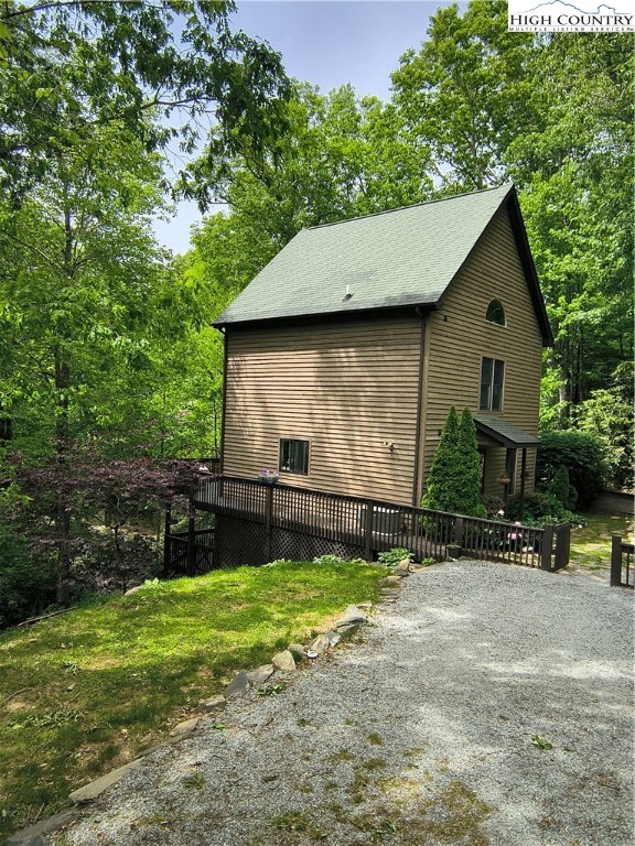 888 Benjamin Drive Boone, NC 28607 - Photo 35 of 38 a backyard of a house with potted plants and a bench