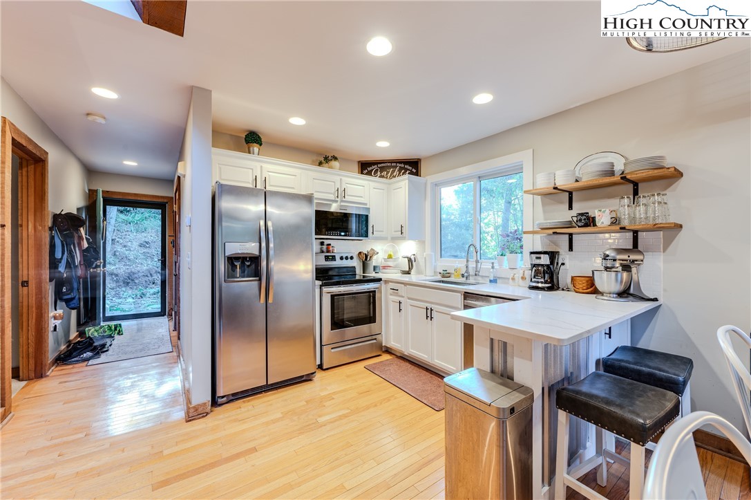 888 Benjamin Drive Boone, NC 28607 - Photo 8 of 38 a kitchen with granite countertop a refrigerator stove top oven and sink