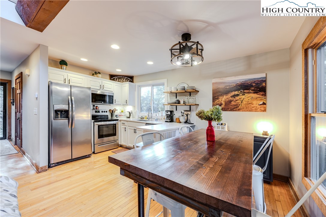 888 Benjamin Drive Boone, NC 28607 - Photo 9 of 38 a kitchen with stainless steel appliances kitchen island granite countertop a table chairs microwave and refrigerator
