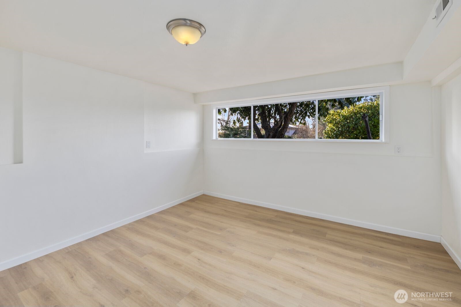 4403 224th Place Southwest Mountlake Terrace, WA 98043 - Photo 23 of 32 an empty room with wooden floor and windows