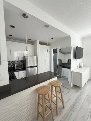 a living room with furniture and kitchen view