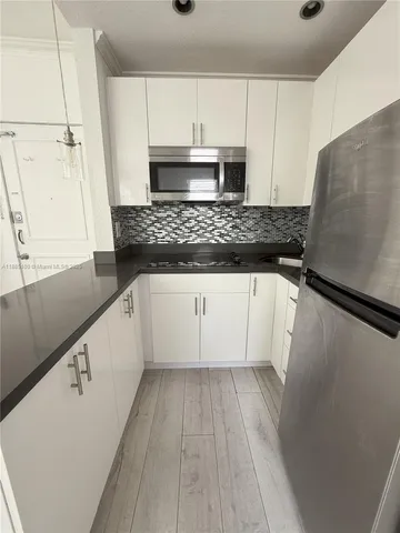 a kitchen with granite countertop a sink a stove and cabinets