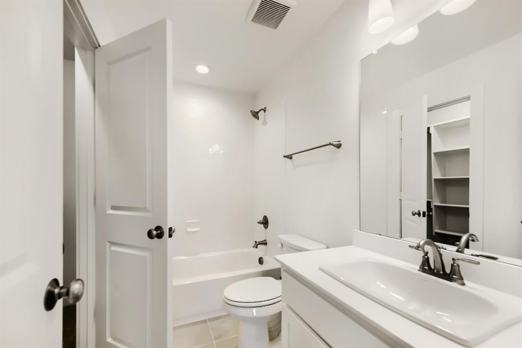 11465 Wulstone Road Fort Worth, TX 76052 - Photo 24 of 27 Bathroom featuring a single vanity with an integrated sink, brushed nickel faucet, and a large mirror