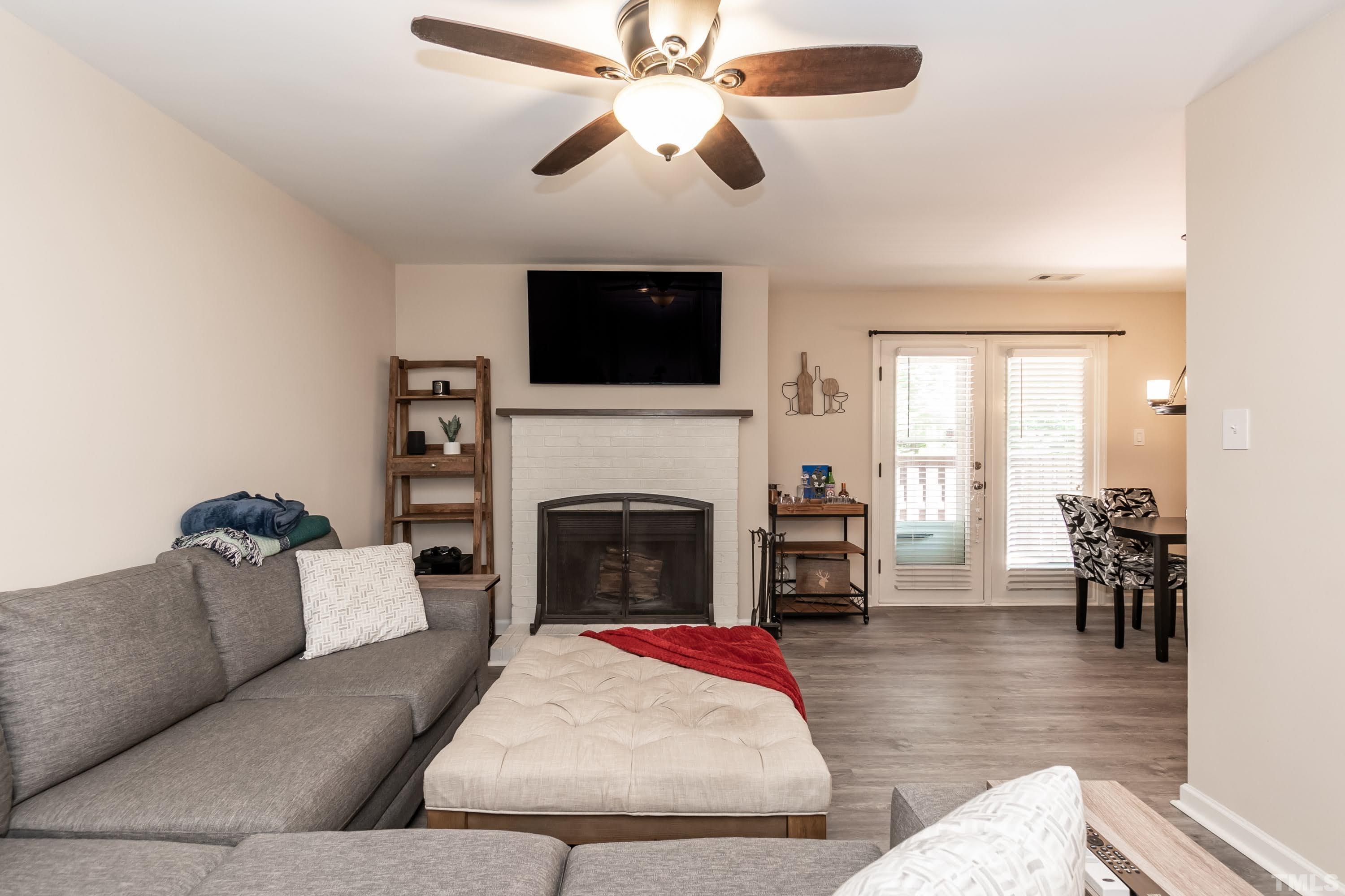 3531 Mill Run, Unit 48 Raleigh, NC 27612 - Photo 7 of 24 a living room with furniture a fireplace and a flat screen tv