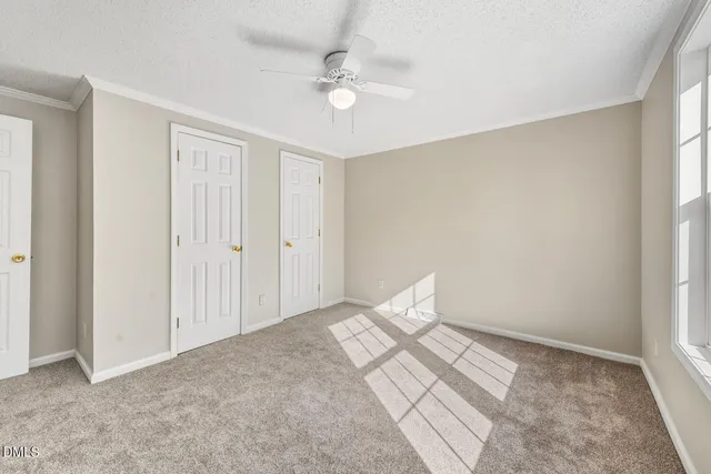 a view of a bedroom with cabinet and a ceiling fan