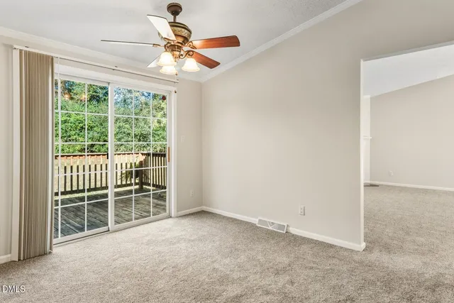 an empty room with windows and a chandelier fan
